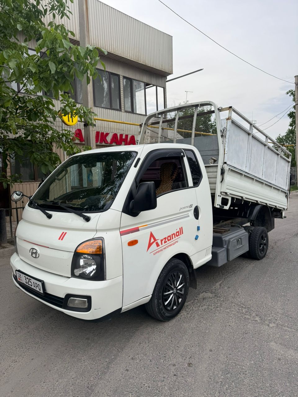 Белый бортовой Porter на городской улице